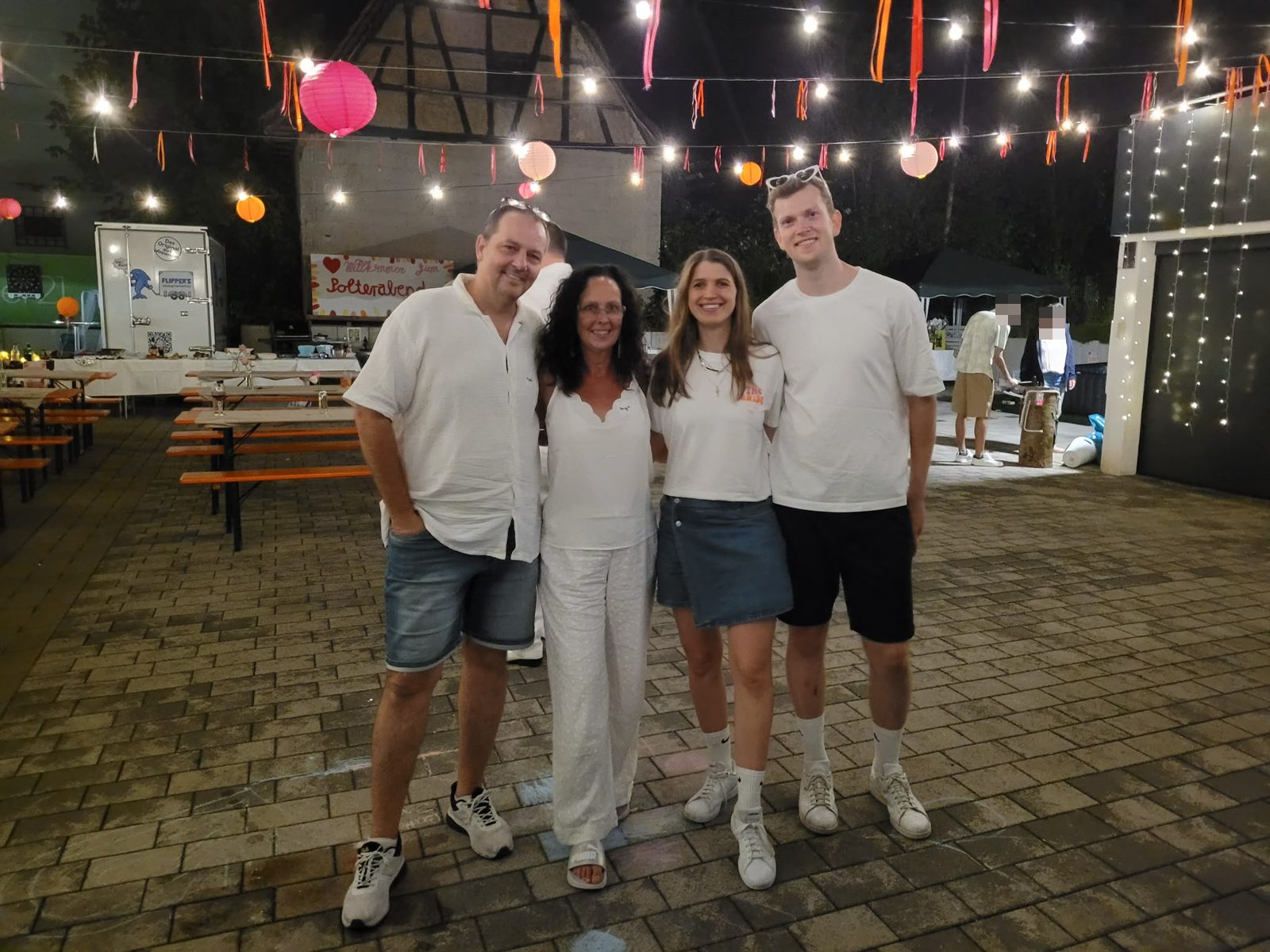 Tobi, Birgit, Carina und Luca lachend auf dem festlich beleuchteten Event